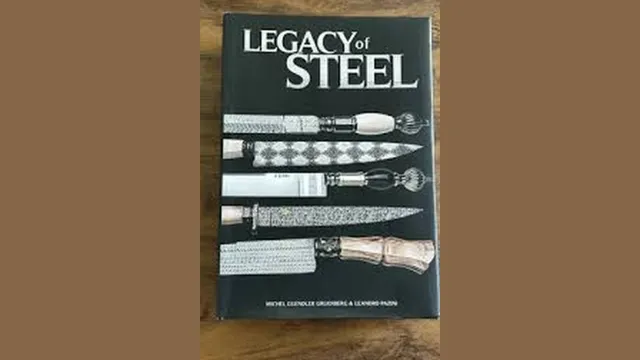 Exemplar do livro Legacy of Steel sobre uma mesa de madeira: capa preta com o título em letras prateadas e cinco facas artesanais fotografadas na vertical, com cabos de marfim, cristal e madeira e lâminas em aço damasco.