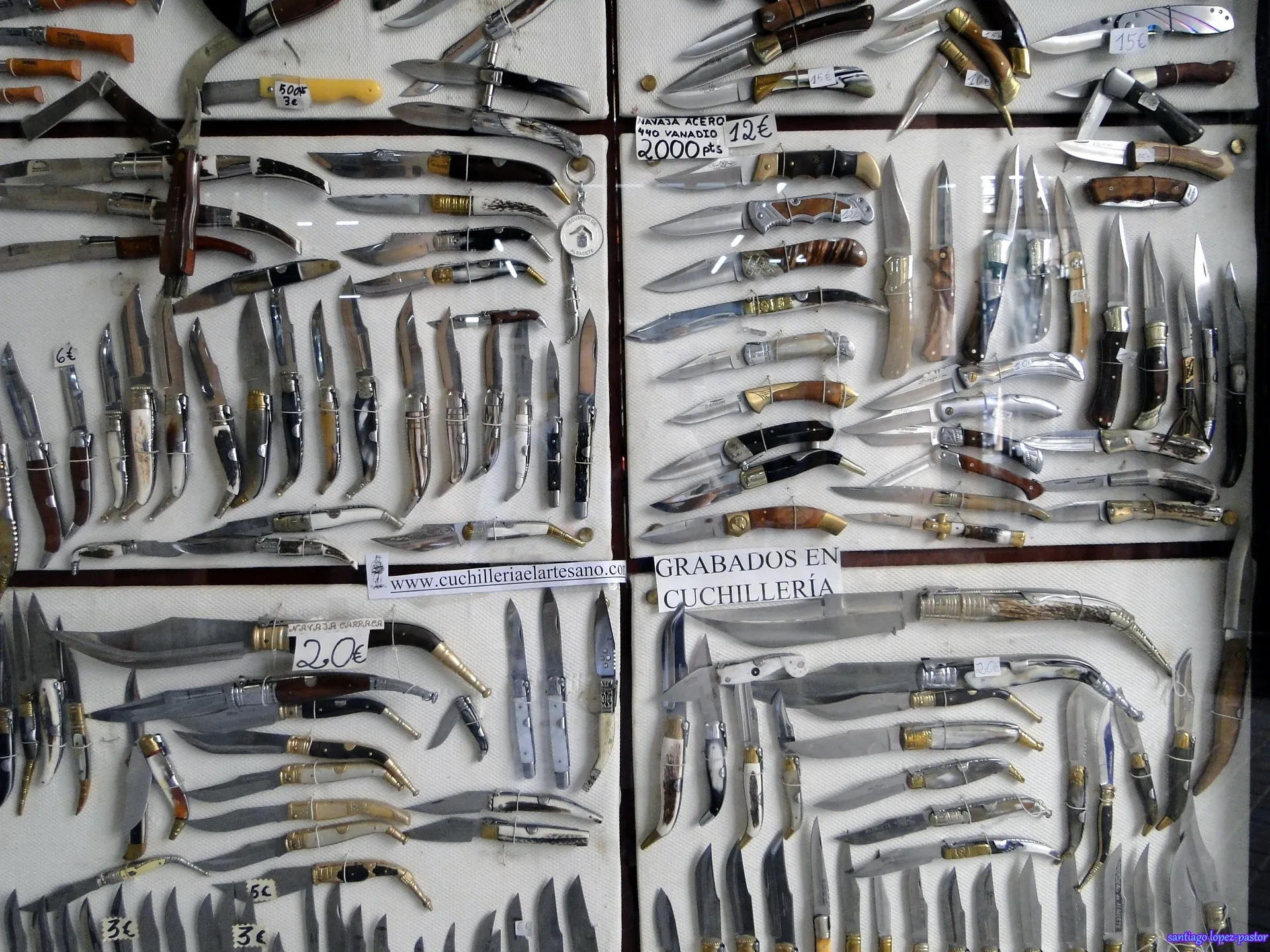 Vitrine de uma cutelaria de Albacete coberta de navalhas e facas de todos os tamanhos, com cabos de chifre, madeira e latão e etiquetas de preço em euros